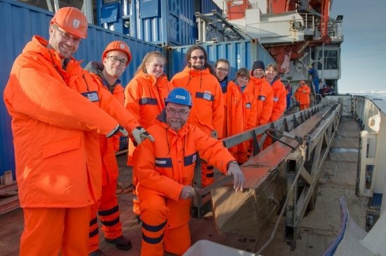 74.1 (c) Joy at a successful extraction of a sediment core bore: Polarstern expedition leader Prof Dr Rüdiger Stein (in blue helmet) and his team posing beside the gravity corer containing the sediment core. (Photo: Alfred Wegener Institute / Audun Tholfsen, UoB)