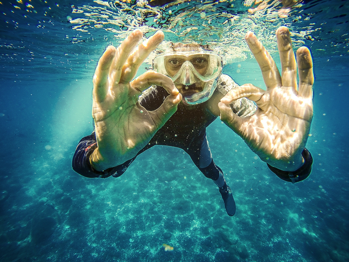Scuba diver underwater showing ok signal with two hands. (c) Scuba diver underwater showing ok signal with two hands.