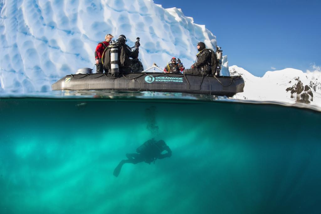 Zodiac in front of iceberg diver Diving Antarctica (c) 