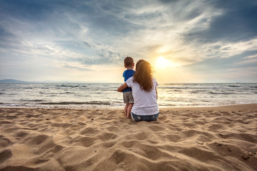 Mother-with-son-enjoying-sunset-on-the-beach-812121760_8635x5757_istock_sankai_LQ